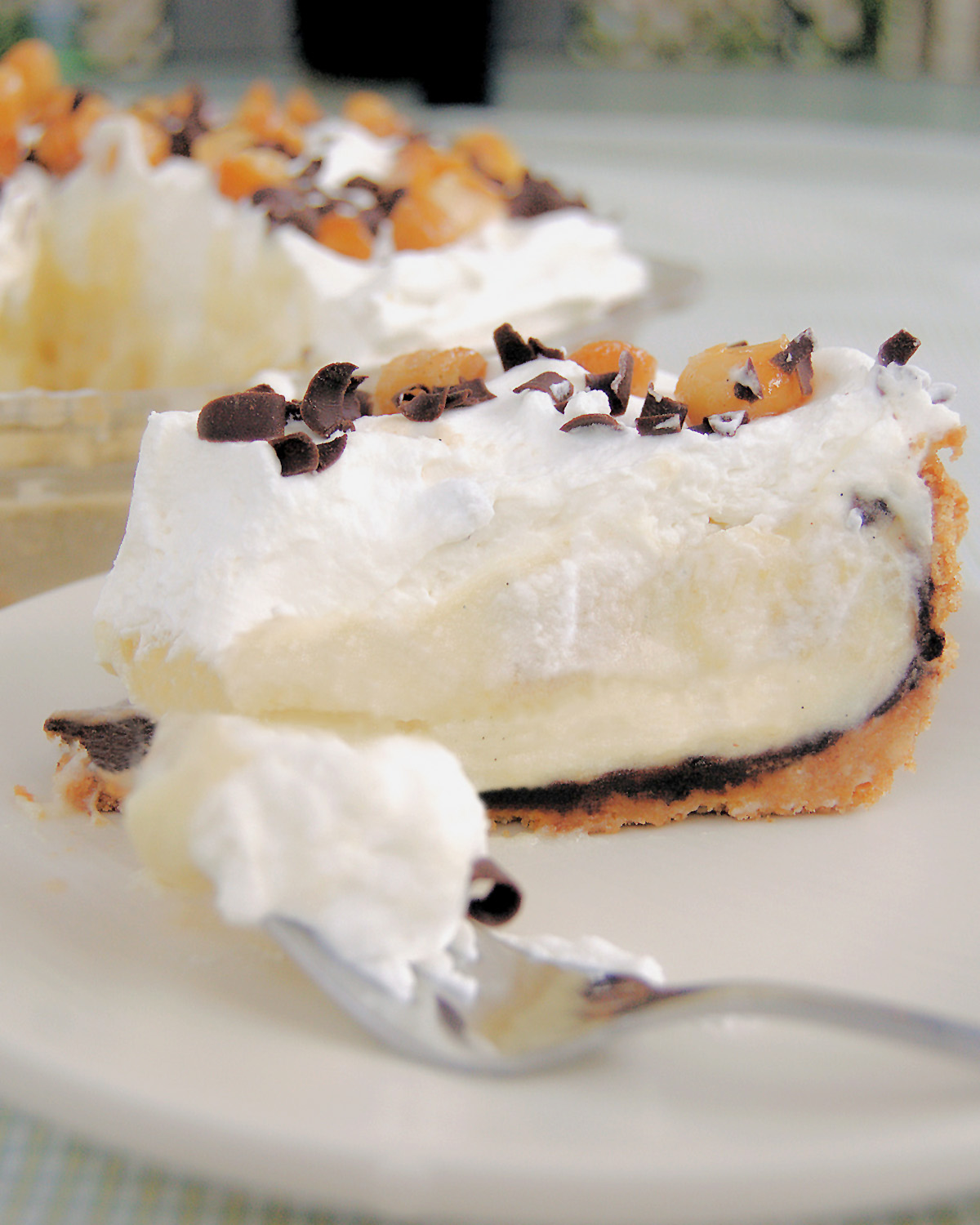 a slice of banana cream pie on a white plate with a fork.