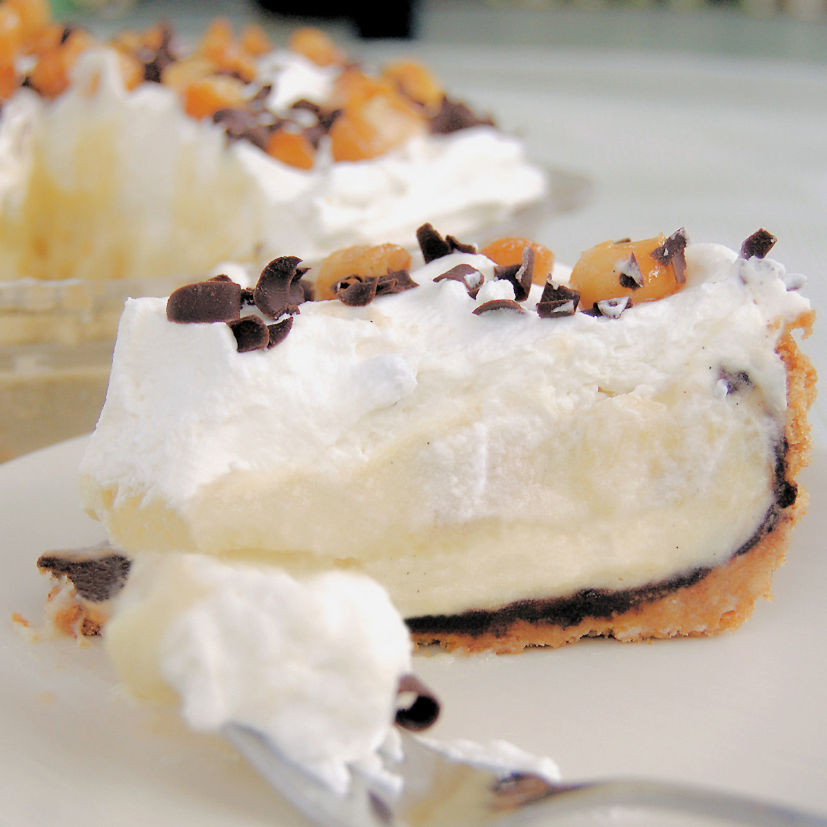 a slice of banana cream pie on a white plate with a fork.