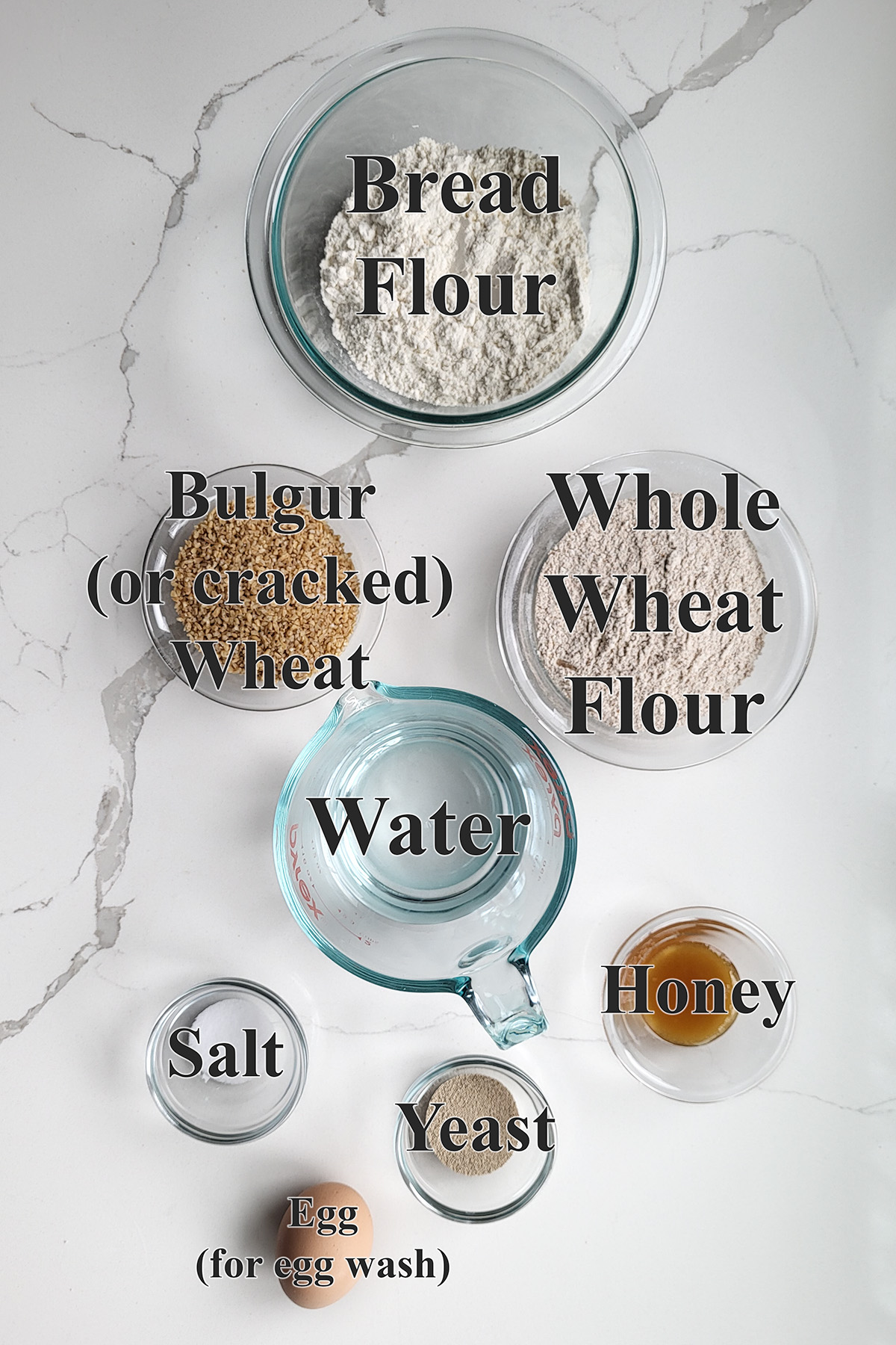 ingredients for cracked wheat bread in glass bowls.