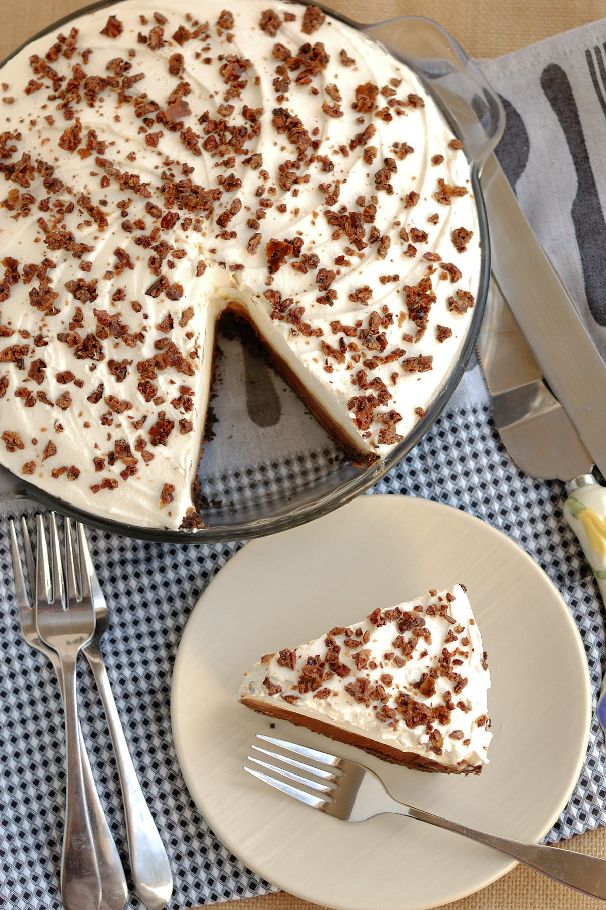 a chocolate cream pie in a pan and a slice of pie on a white plate. 