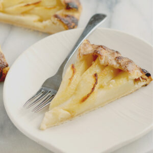 a slice of pear galette on a white plate.