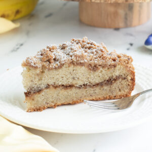 a slice of banana coffee cake on a white plate.