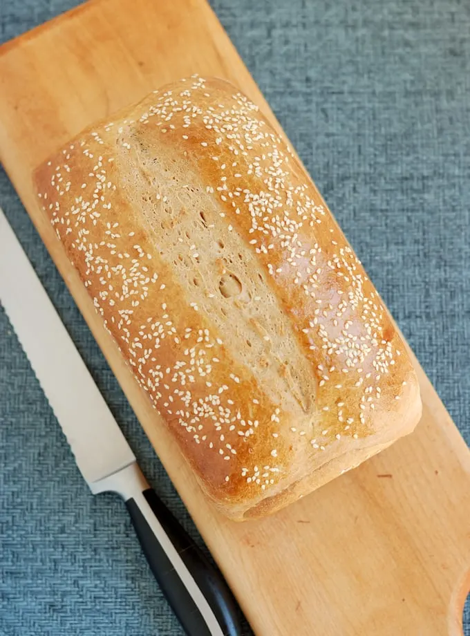 a loaf of milk & honey whole wheat bread on a cutting board.
