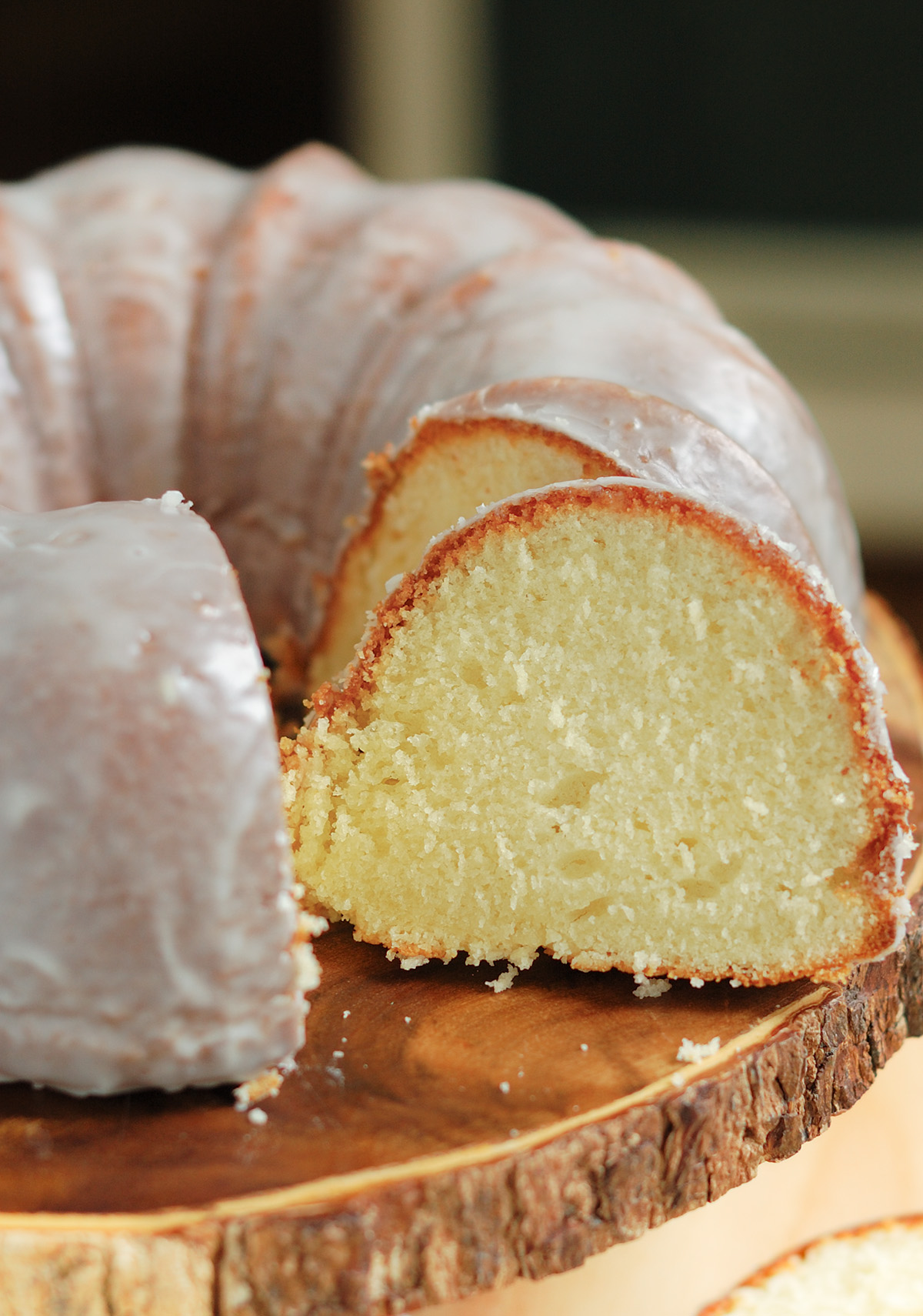 a sliced buttermilk bundt cake on a wooden cake stand