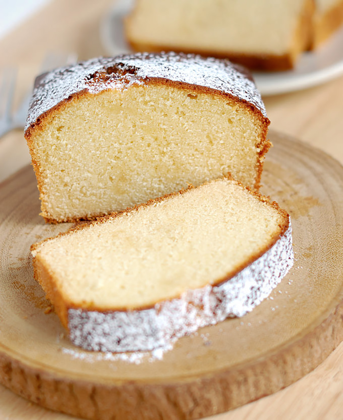 a sliced honey pound cake on a wooden plate.