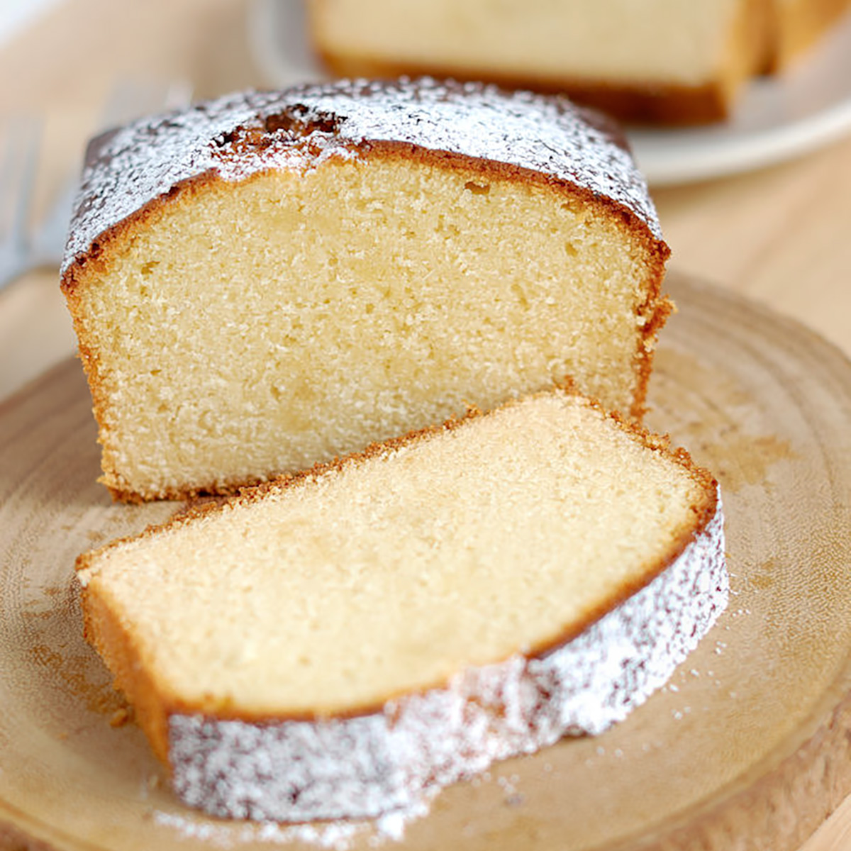 a sliced pound cake on a wodden plate.