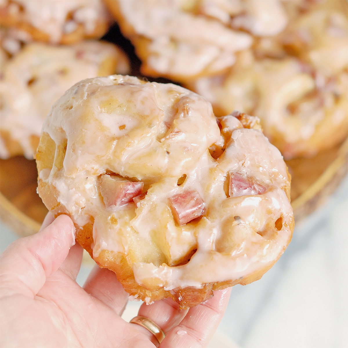 a hand holding a large rhubarb fritter.