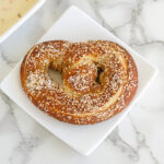 a sourdough soft pretzel on a white plate.