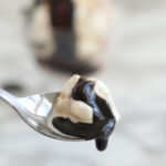 a spoonful of ice cream topped with hot fudge sauce.