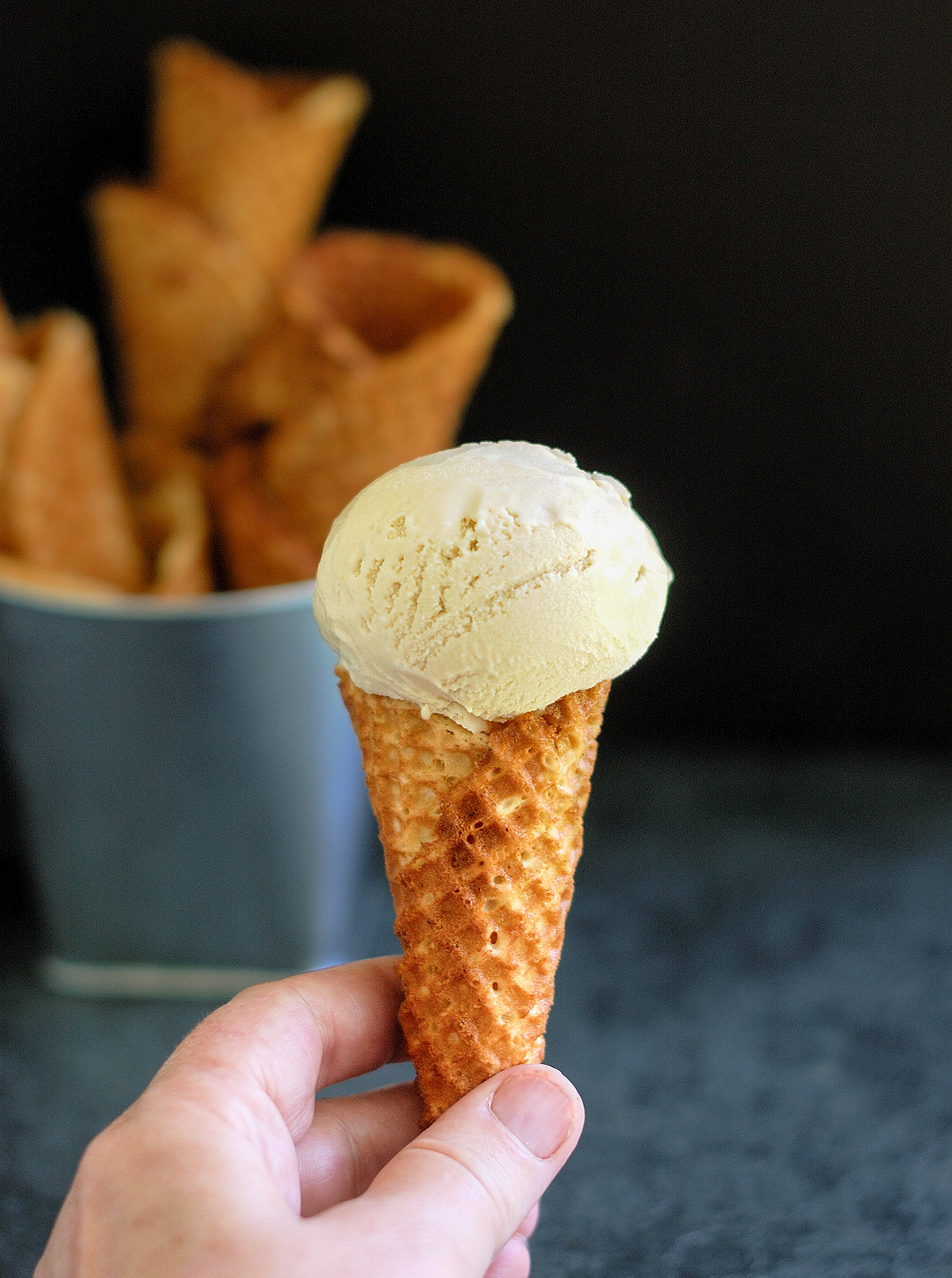 a hand holding an ice cream cone.