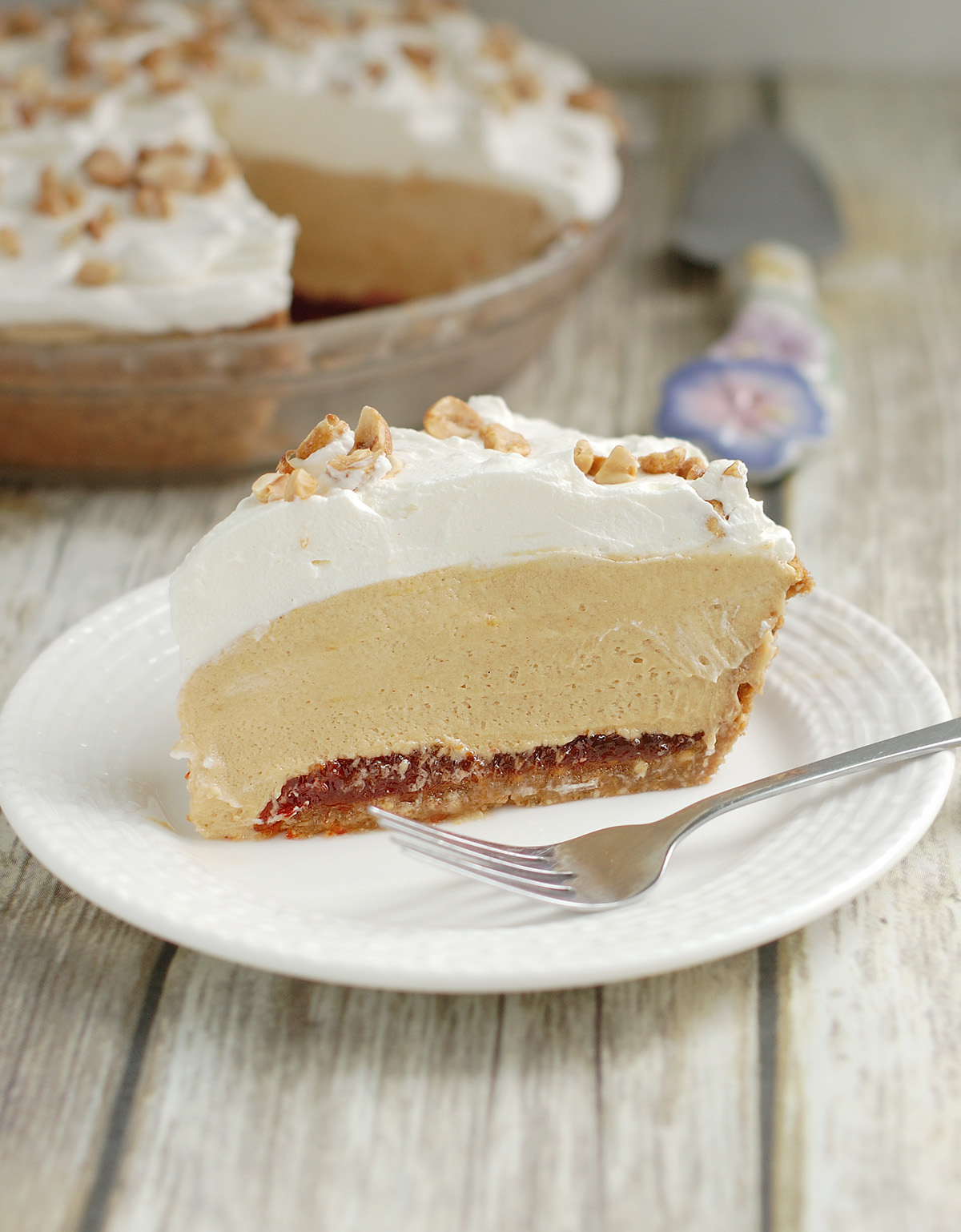 a slice of peanut butter mousse pie on a white plate with a fork.