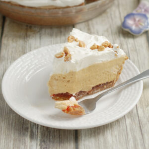 a slice of peanut butter mousse pie on a white plate with a fork.