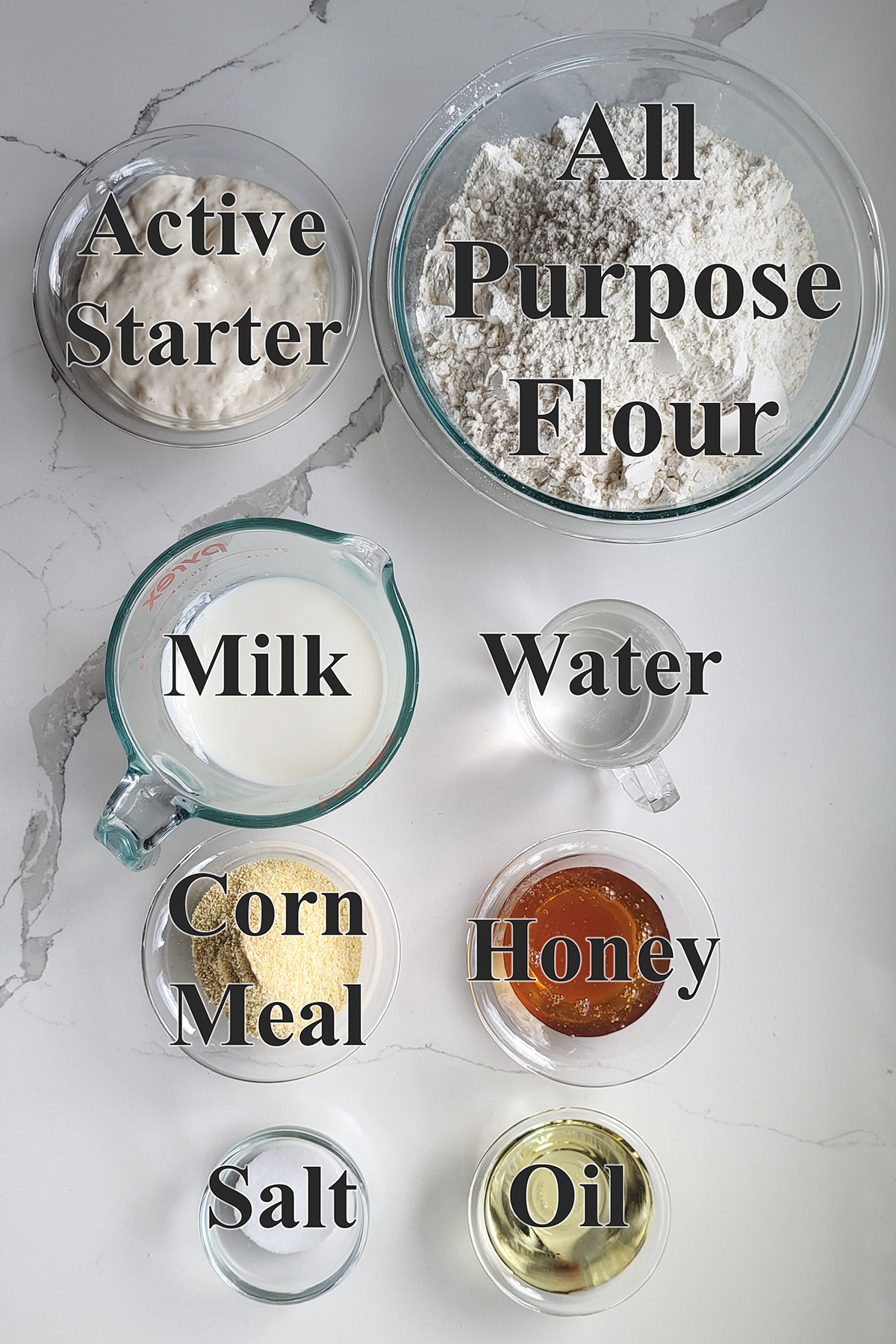 ingredients for sourdough english muffins in glass bowls.