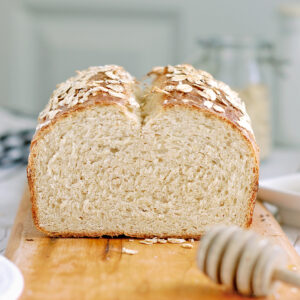 a loaf of oatmeal bread on a cutting board.