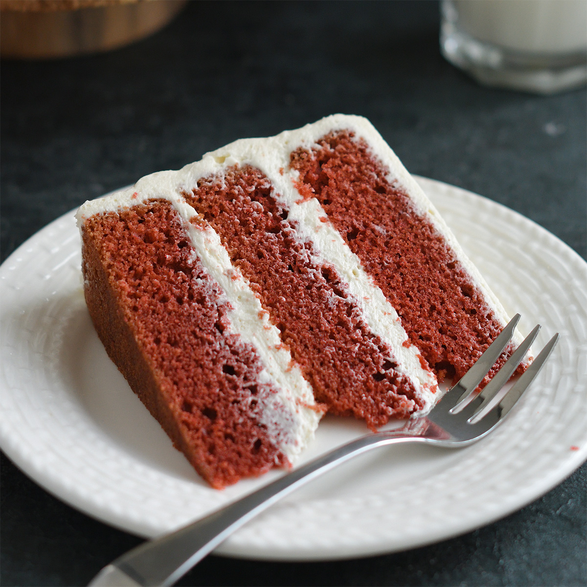 a slice of red velvet cake on a white plate.