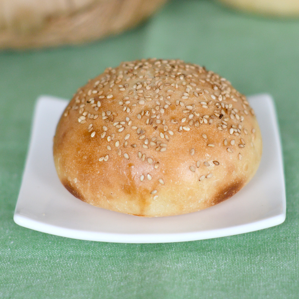 a sourdough hamburger bun on a white plate.