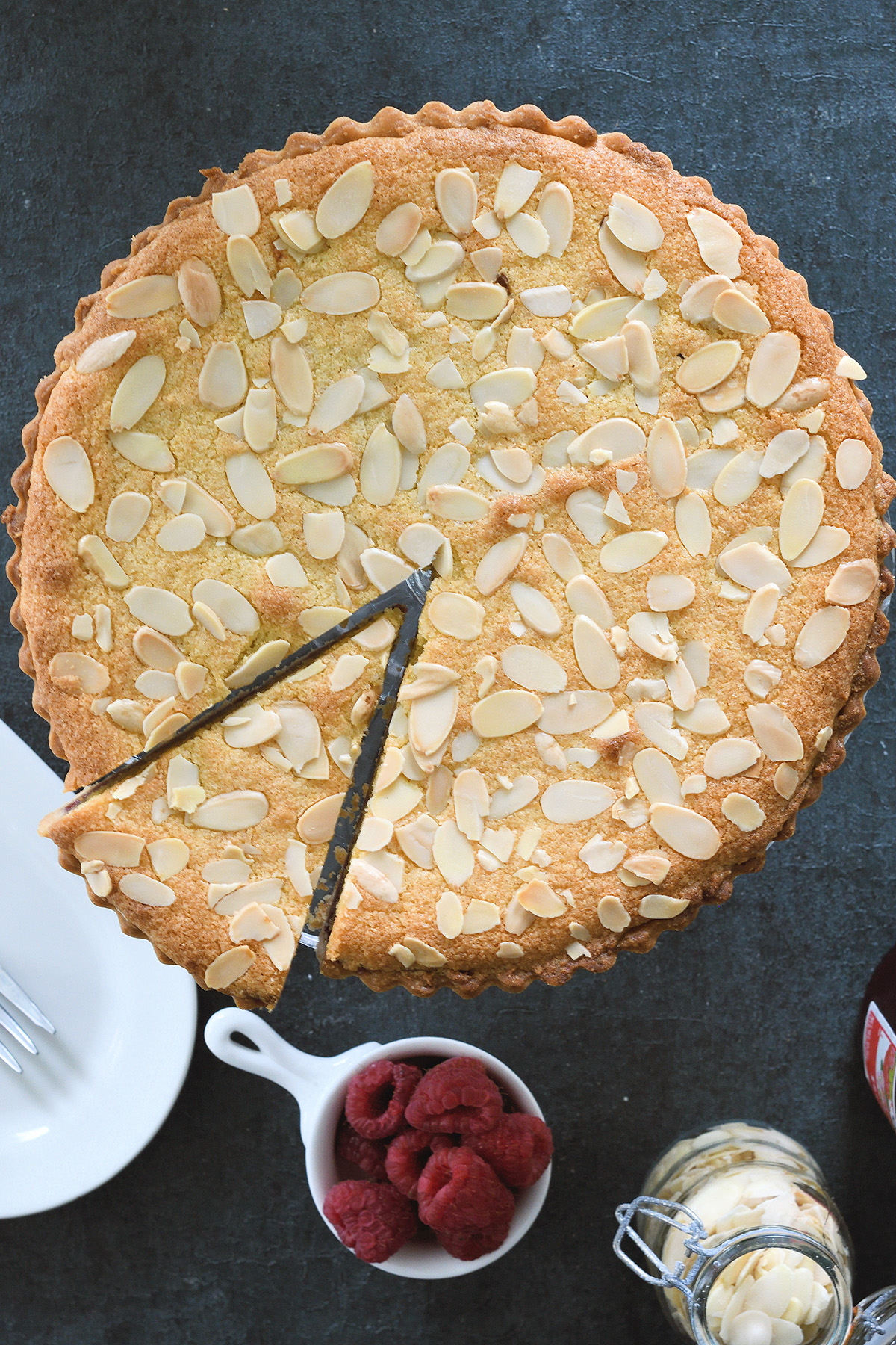 a bakewell tart with a slice cut.