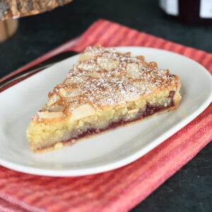 a slice of bakewell tart on a white plate.