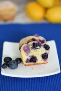 a lemon blueberry muffin cut in half on a plate