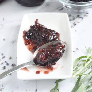 a spoonful of blackberry preserves on a white plate.