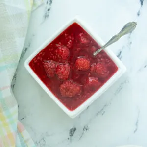 a bowl of raspberry compote with a spoon.