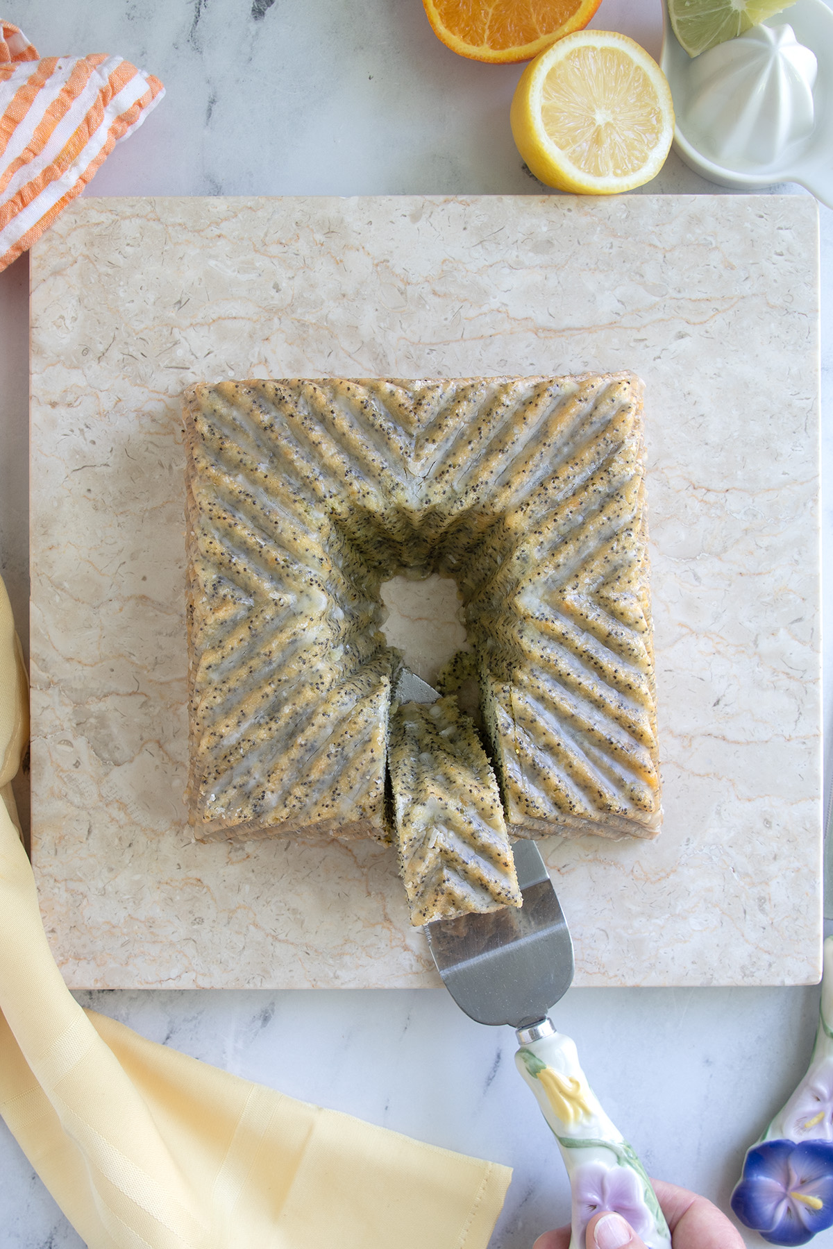 a sliced poppy seed cake on a marble plate.