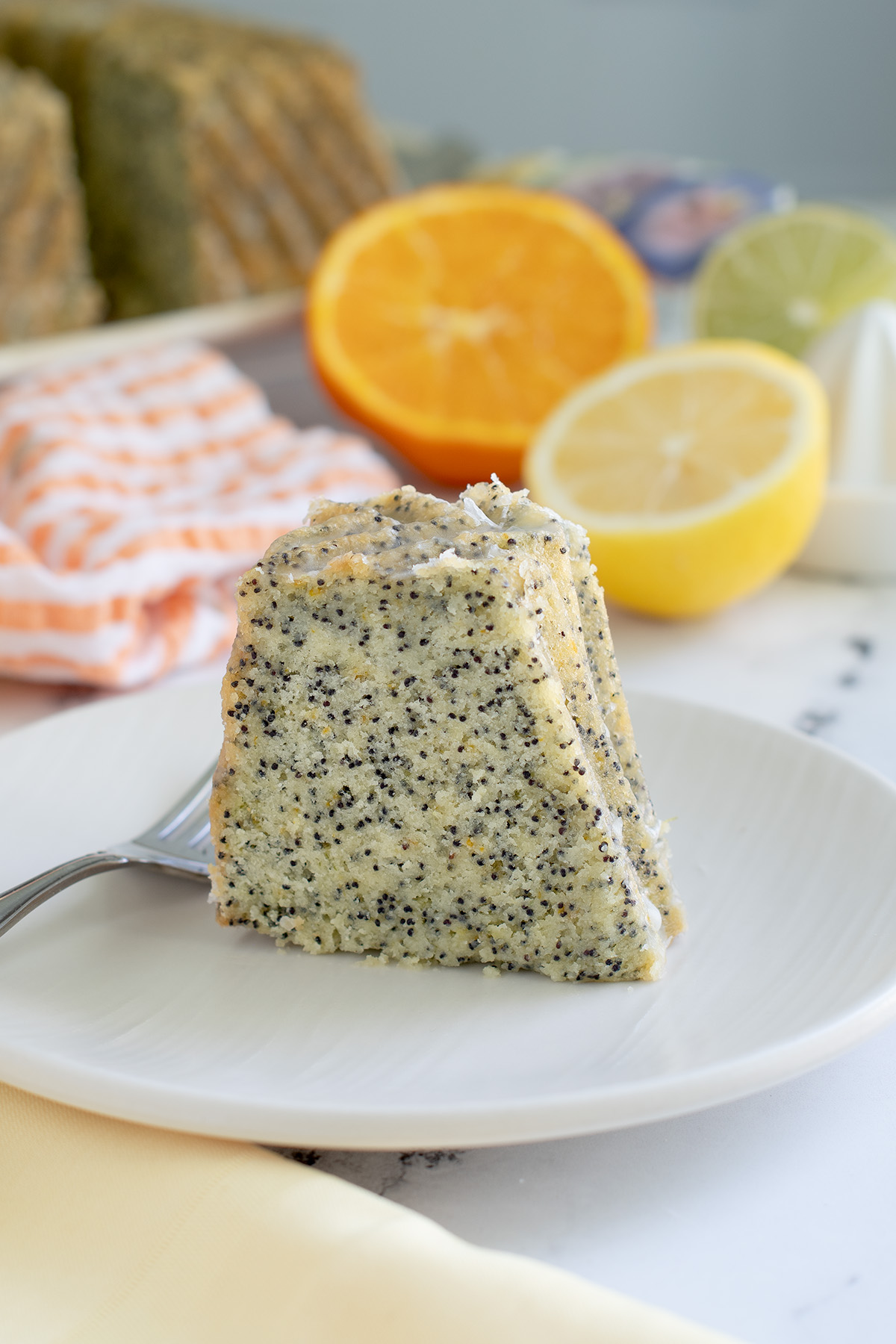 a slice of poppy seeds cake on a white plate.