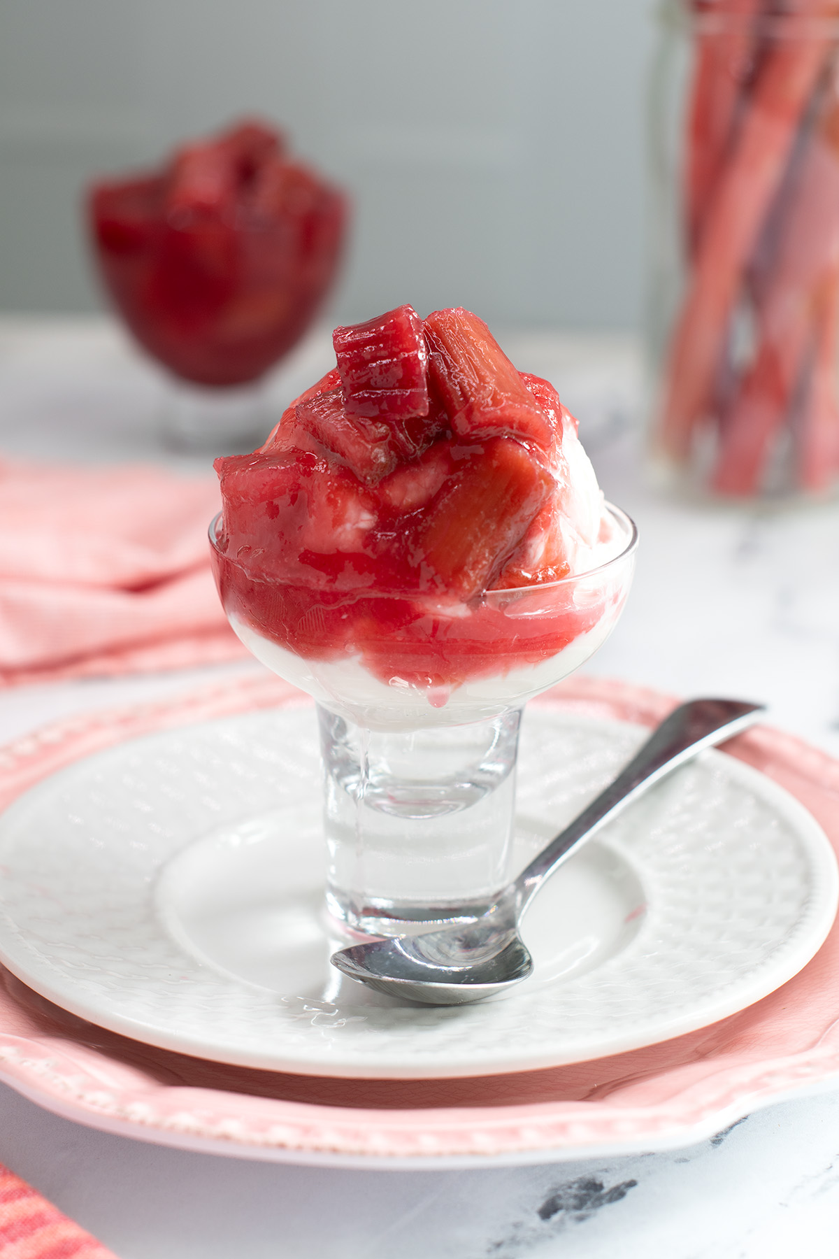a glass bowl filled with yogurt and rhubarb compote.