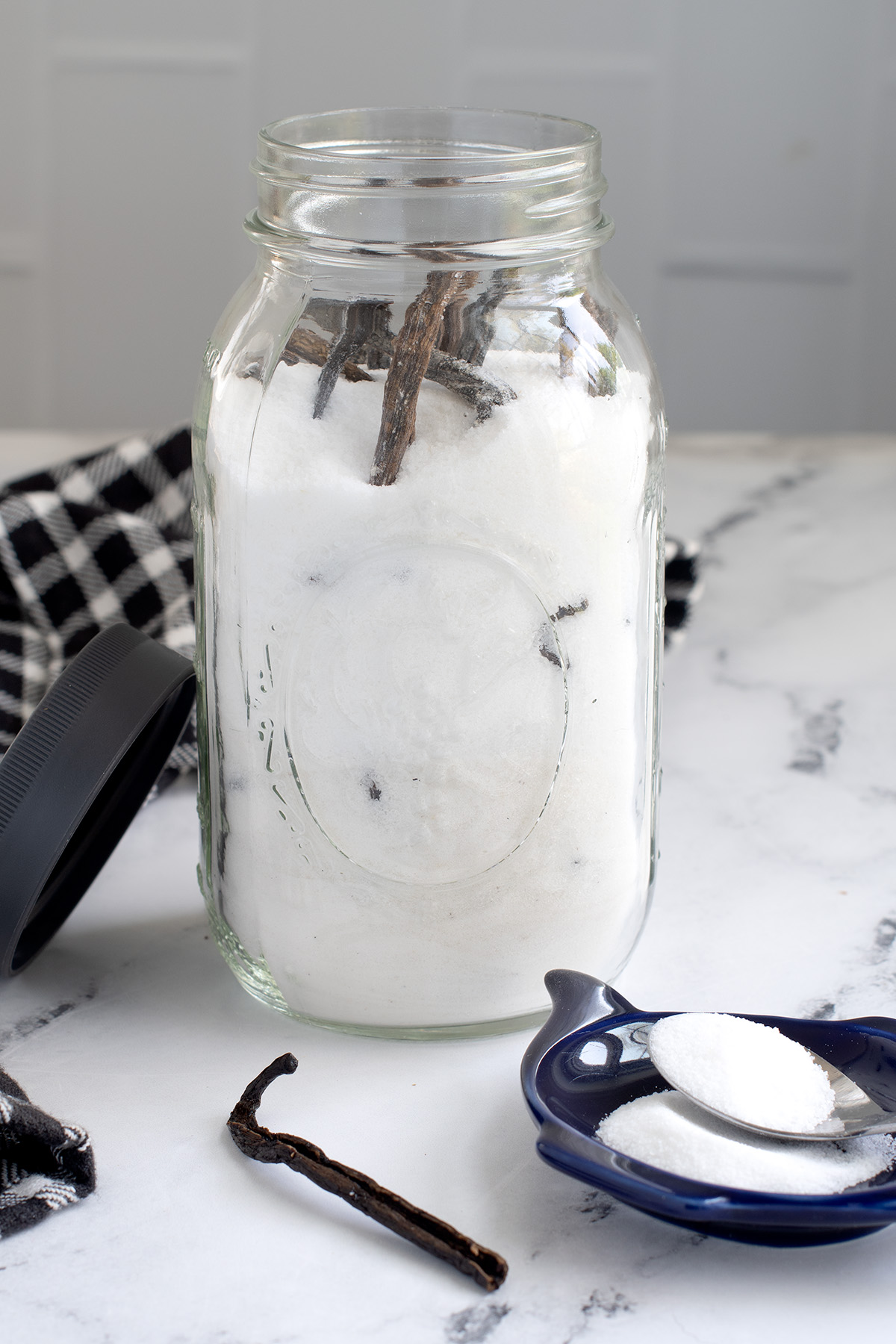 a jar filled with sugar and vanilla beans.