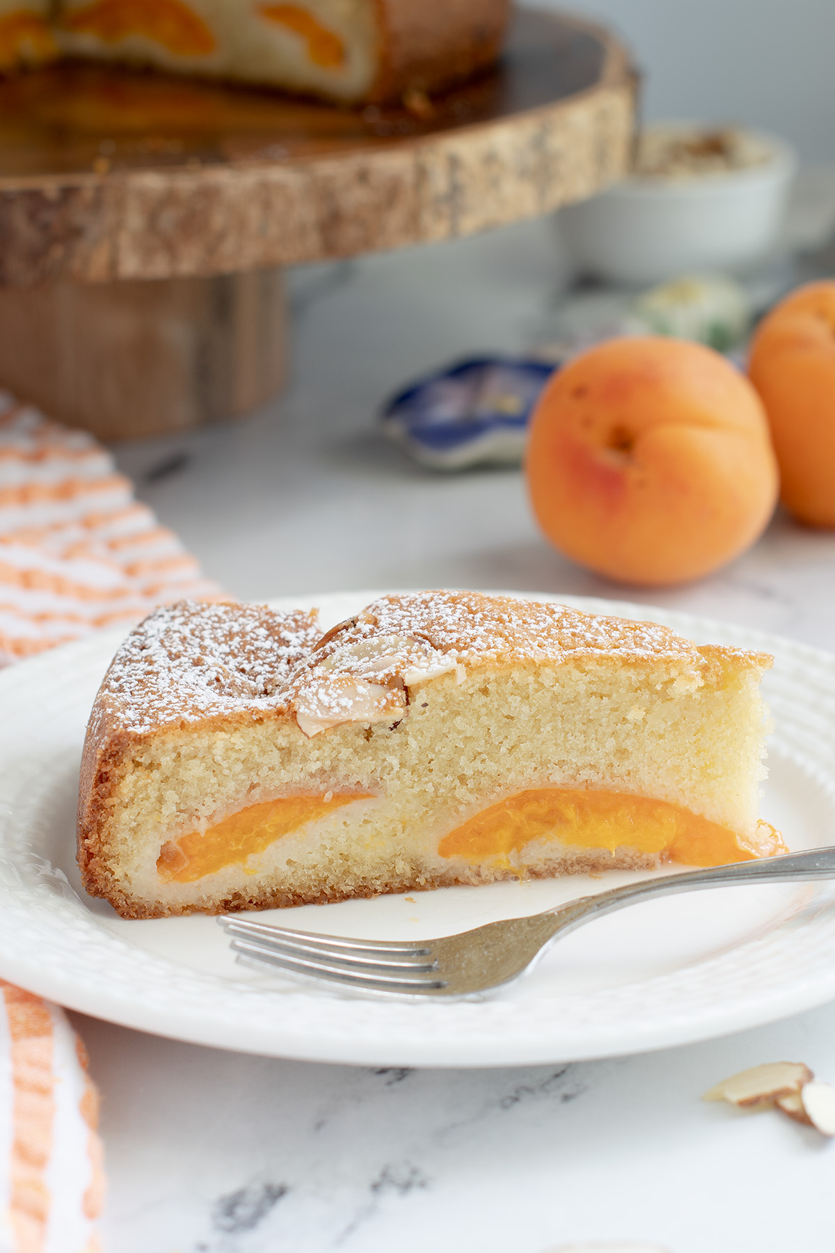 a slice of apricot cake on a white plate.