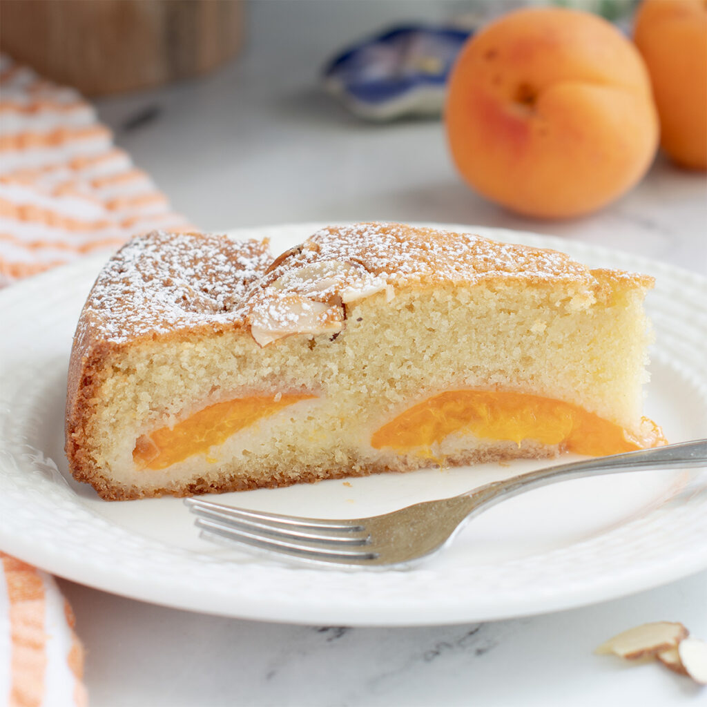 a slice of apricot cake on a white plate.