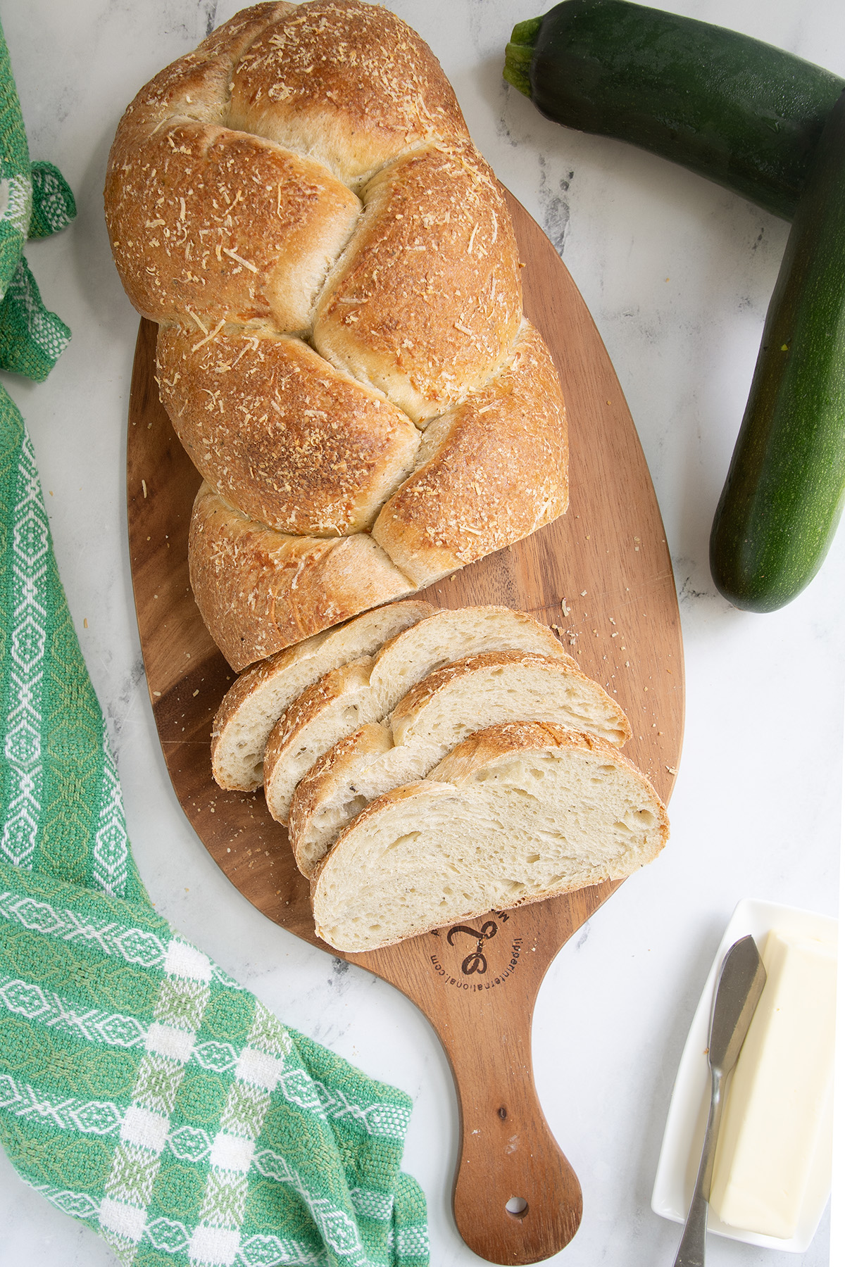 a loaf of braided sourdough bread on a cutting board. 