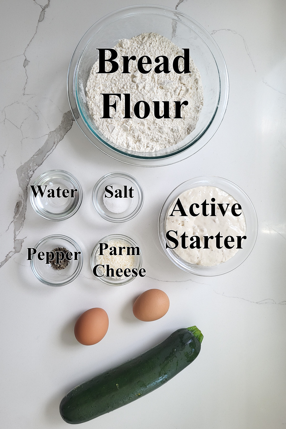 ingredients for sourdough bread with zucchini in glass bowls.