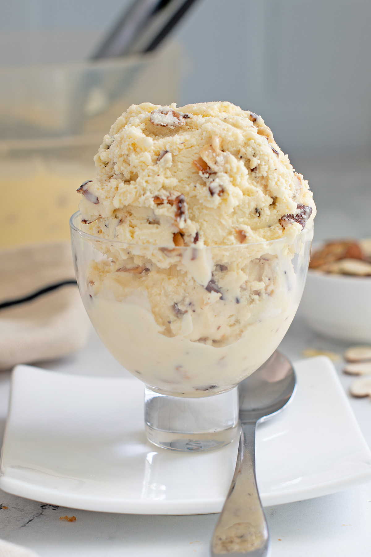 a glass bowl filled with almond ice cream.