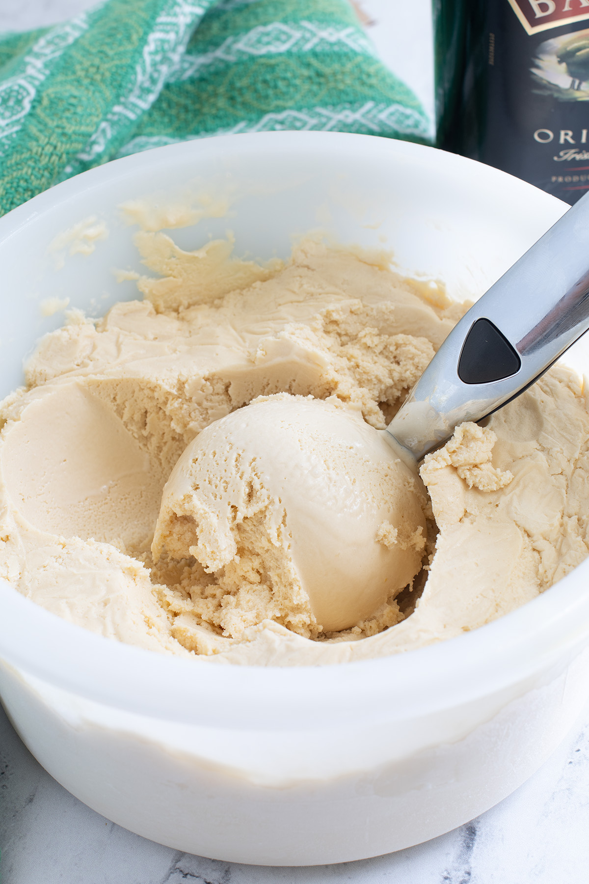 a container of baileys ice cream with a scooper.