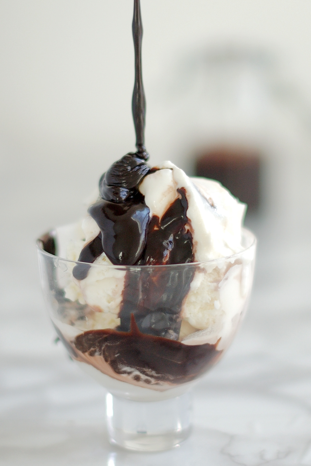 a bowl of ice cream with port wine hot fudge sauce drizzled on top.