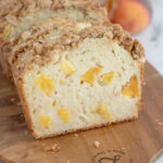 a loaf of sliced peach bread on a cutting board.