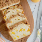 Slices of peach bread on a wooden cutting board.