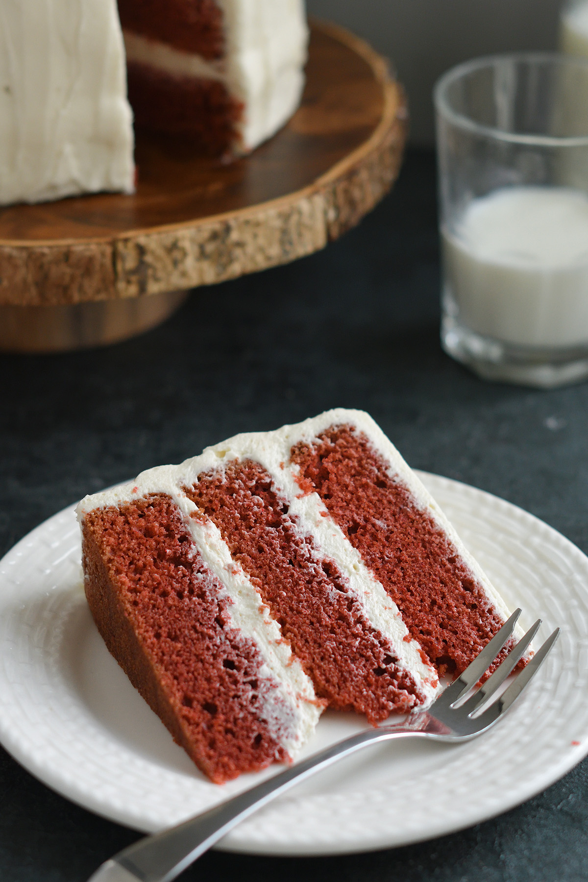 a slice of red velvet cake on a white plate.