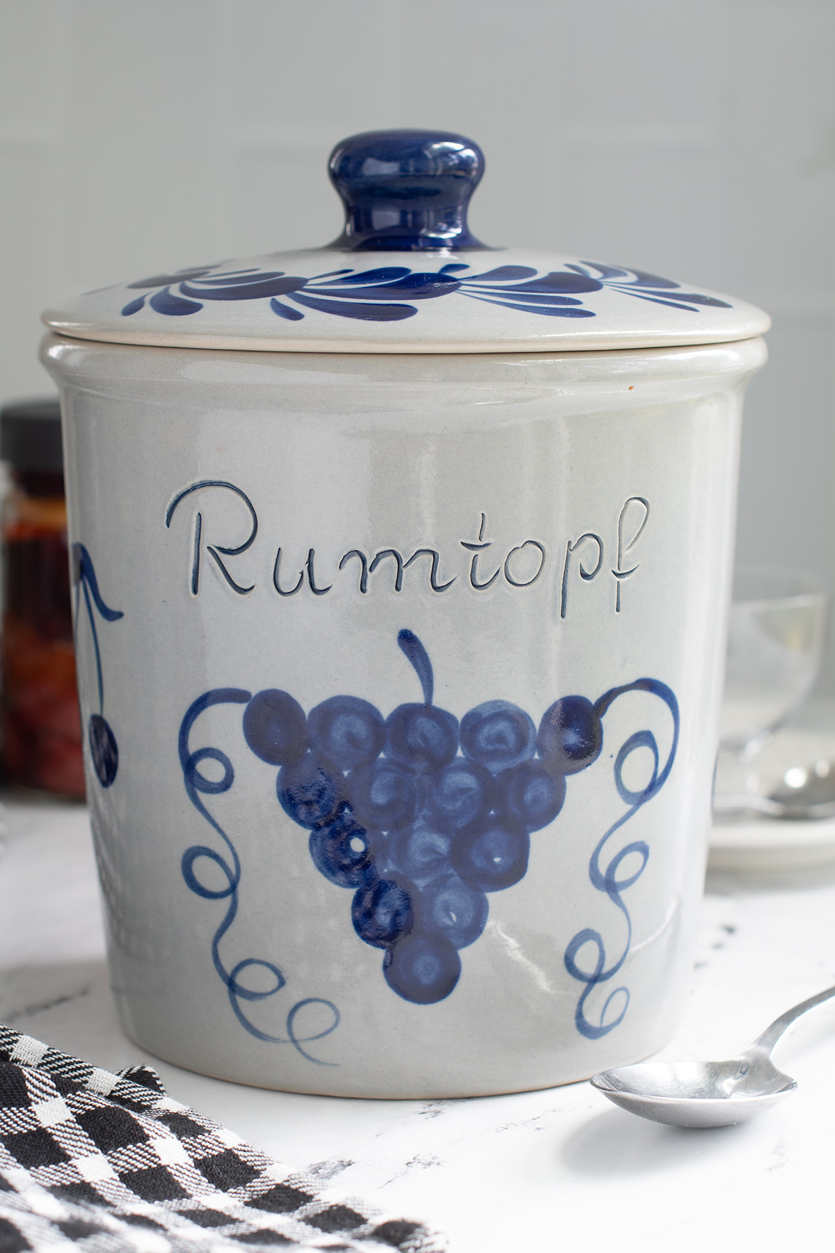 a blue and gray crock with a lid and the word rumtopf on the front.