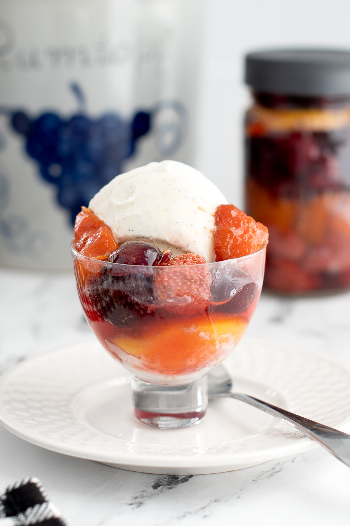 a glass bowl filled with ice cream and fruit.