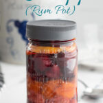 a glass jar filled with fruit and rum.