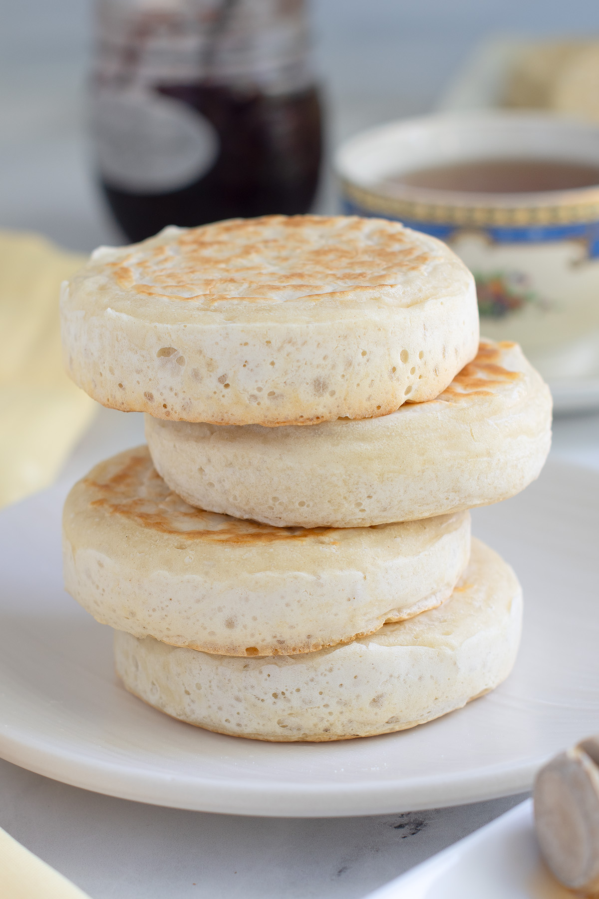 a stack of crumpets on a white plate.