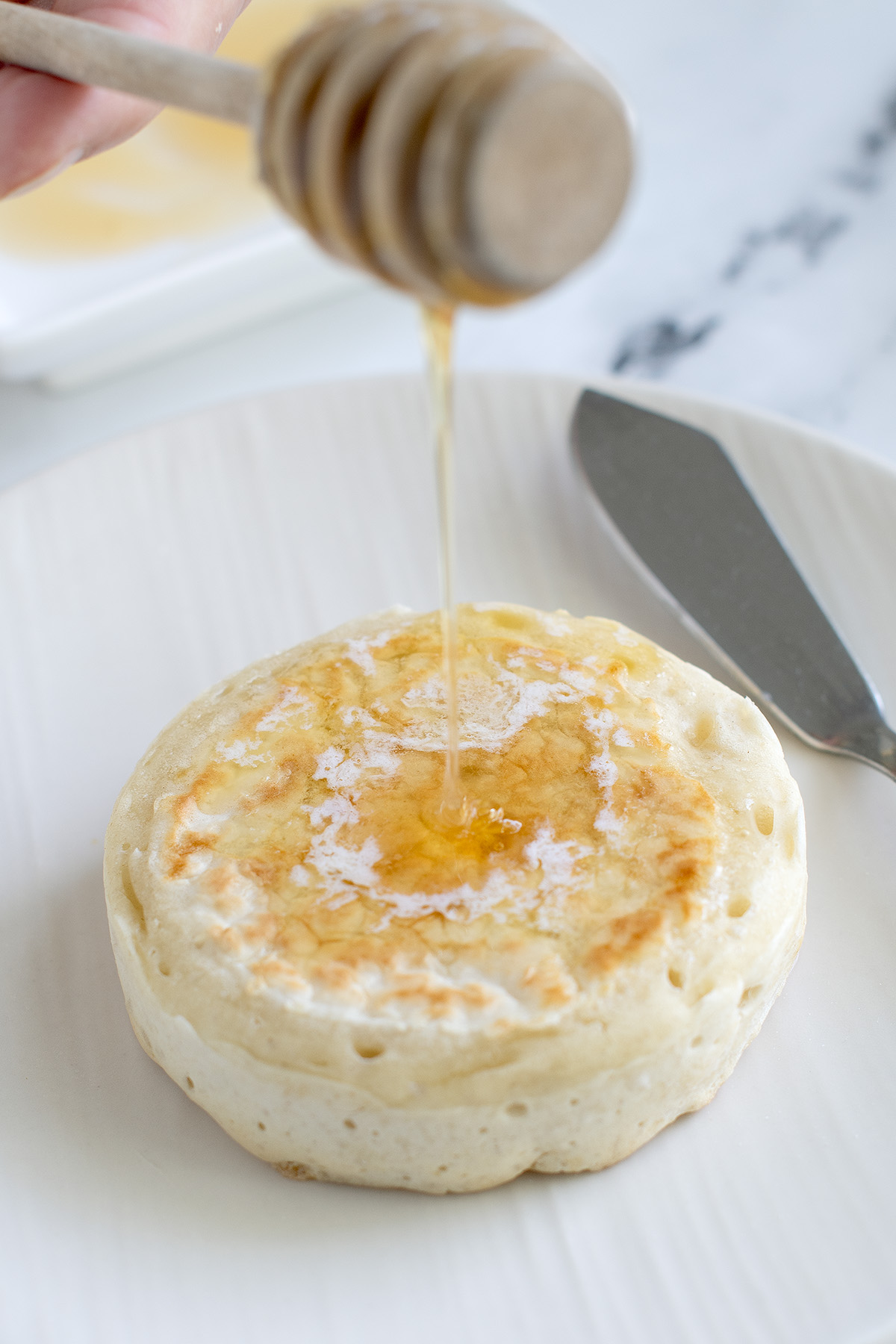 a crumpet on a white plate.