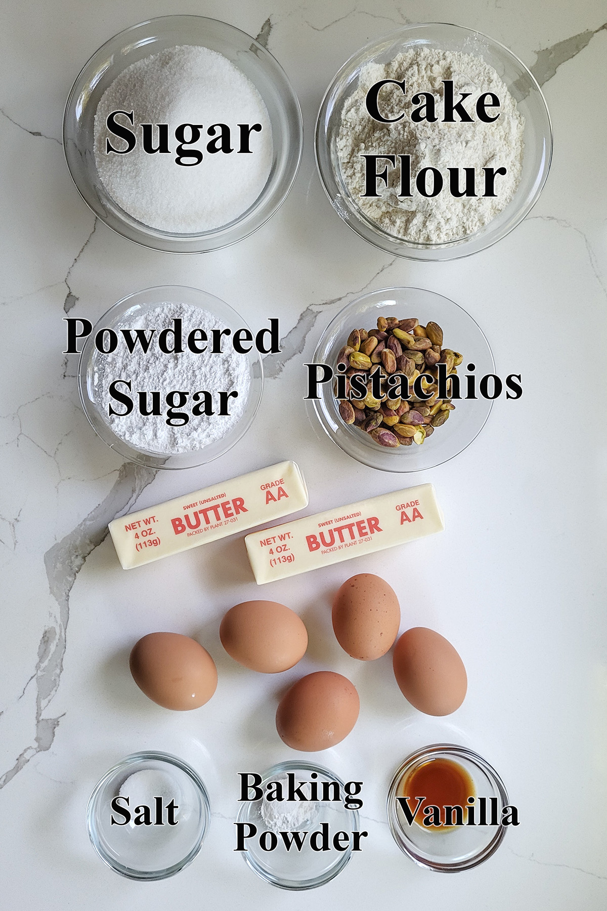 ingredients for pistachio pound cake in glass bowls.