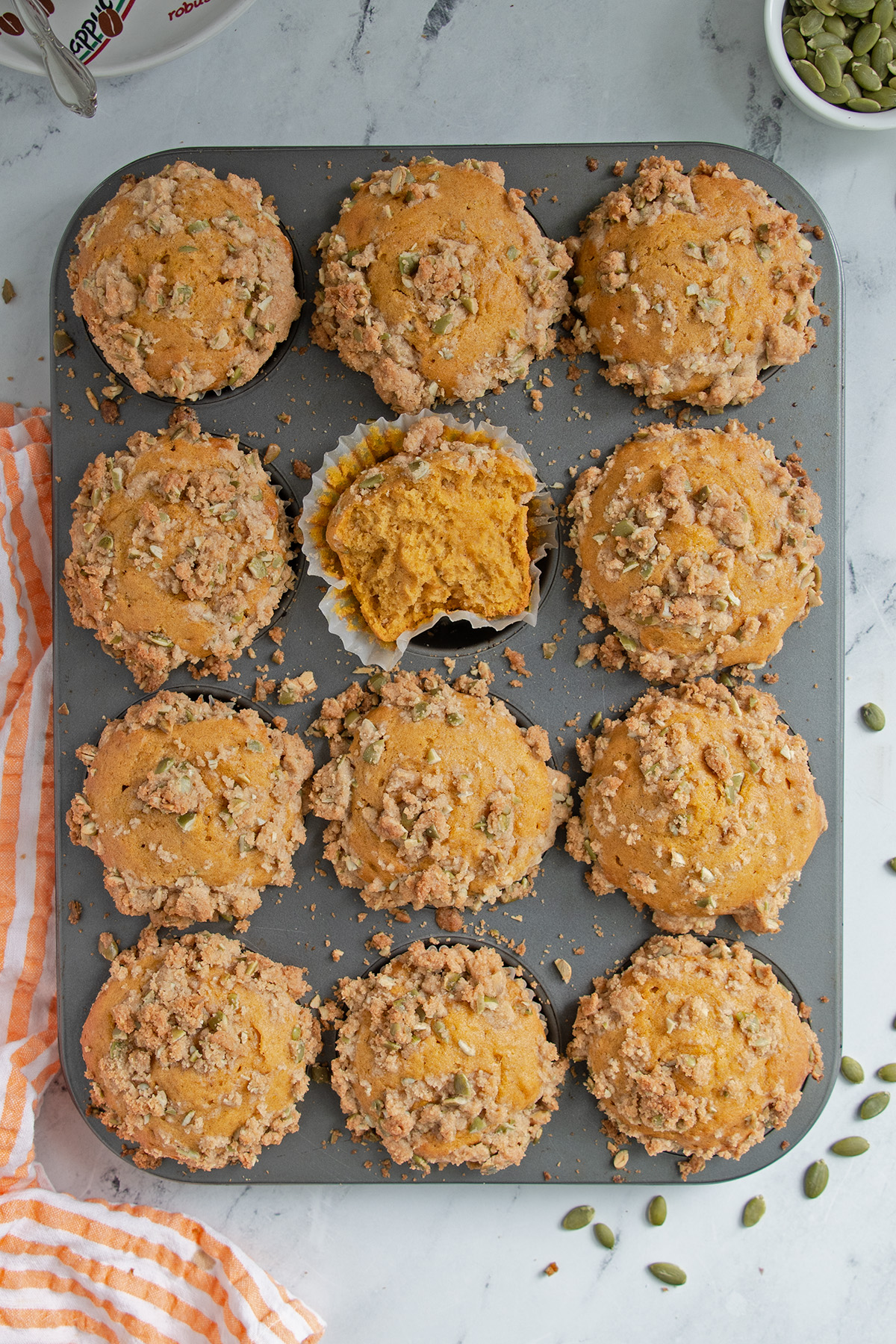 a muffins pan filled with baked pumpkin muffins.