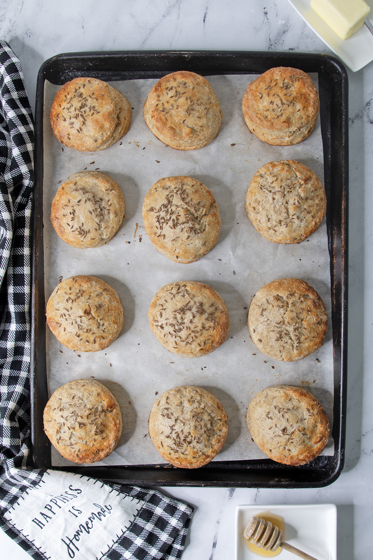 a tray of rye scones on a marble table along with a black and white tea towel.