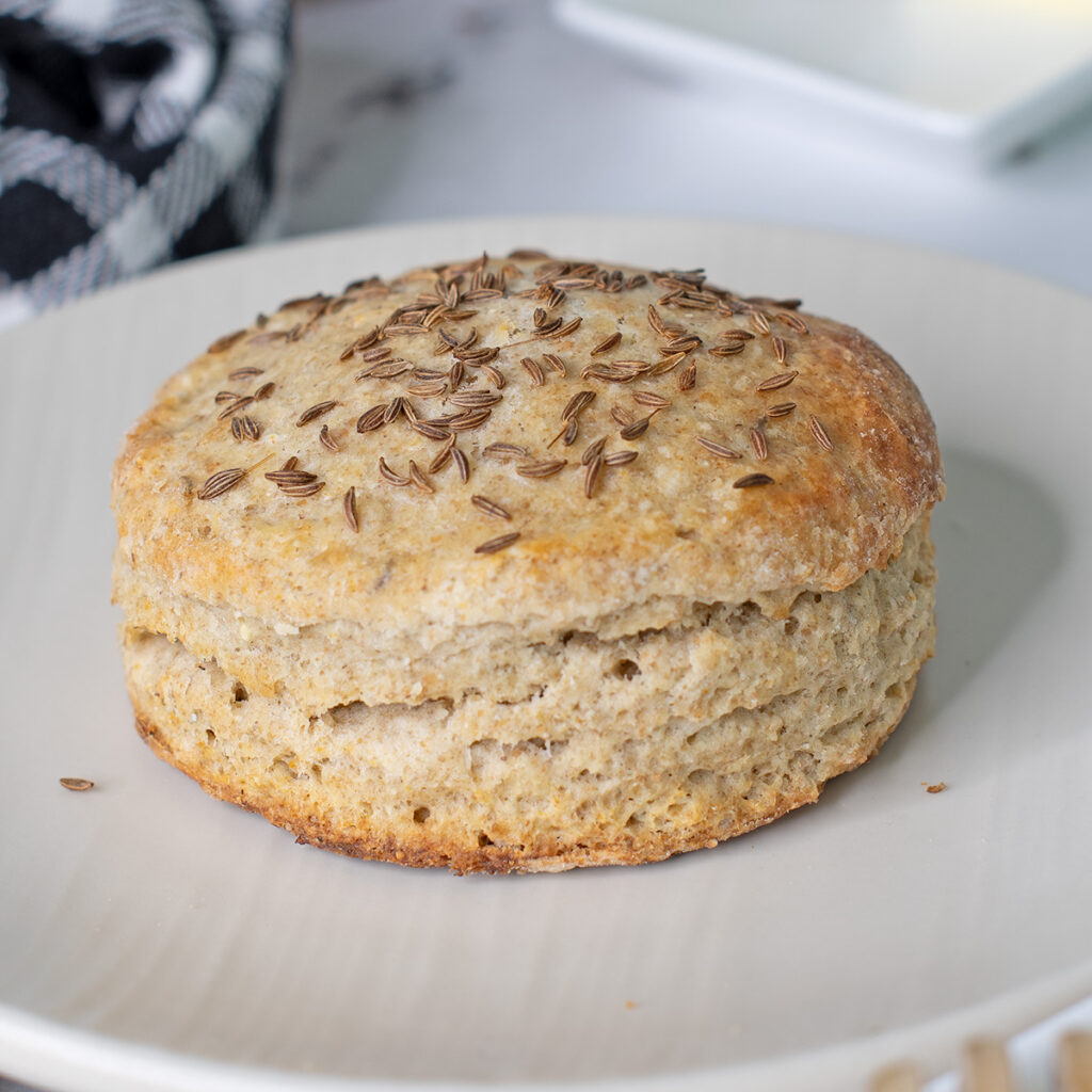 a rye scone on a white plate.