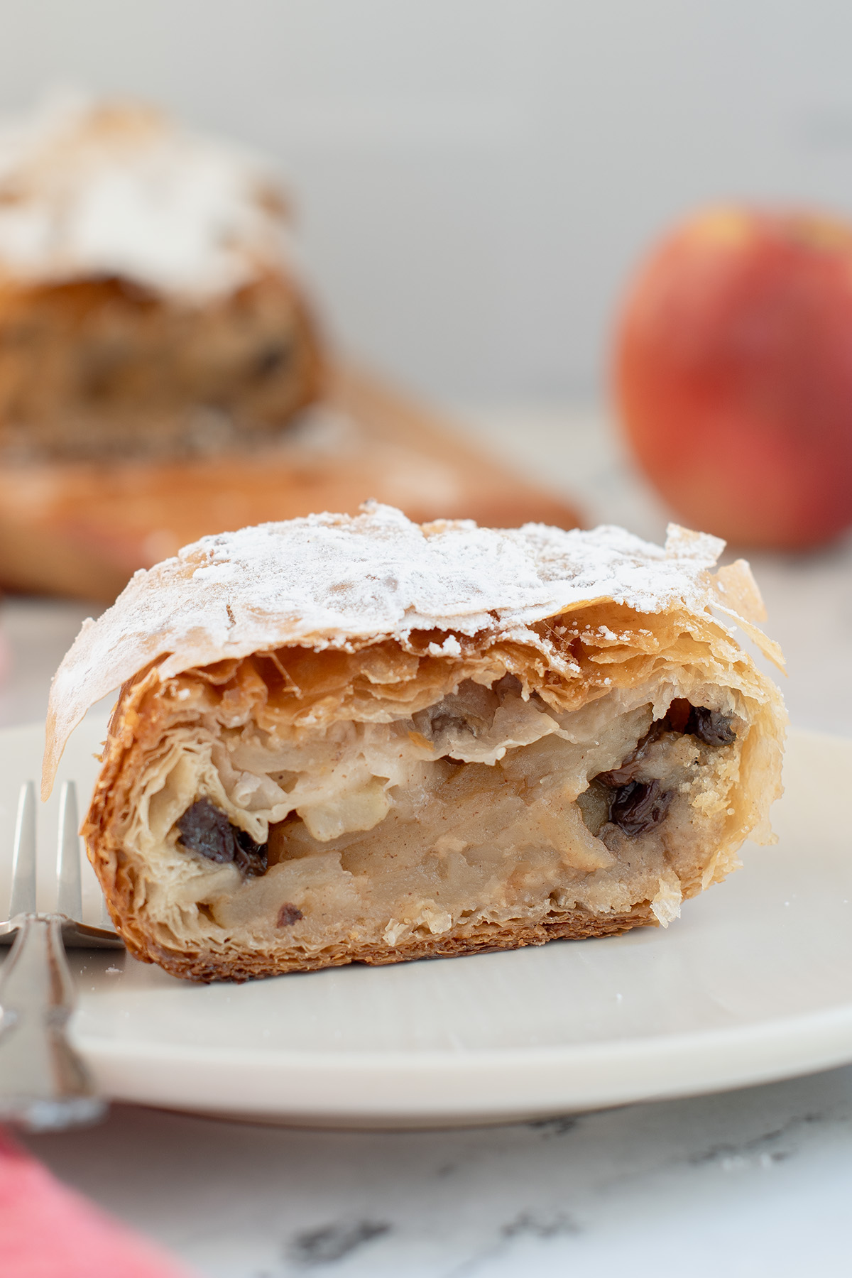 a slice of apple strudel on a white plate.