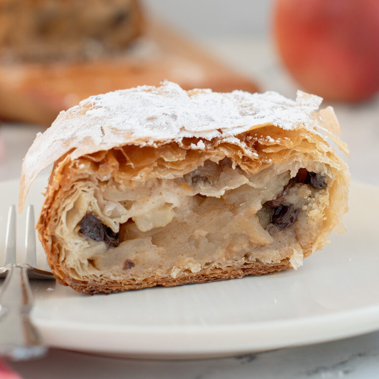 a slice of apple strudel on a white plate.